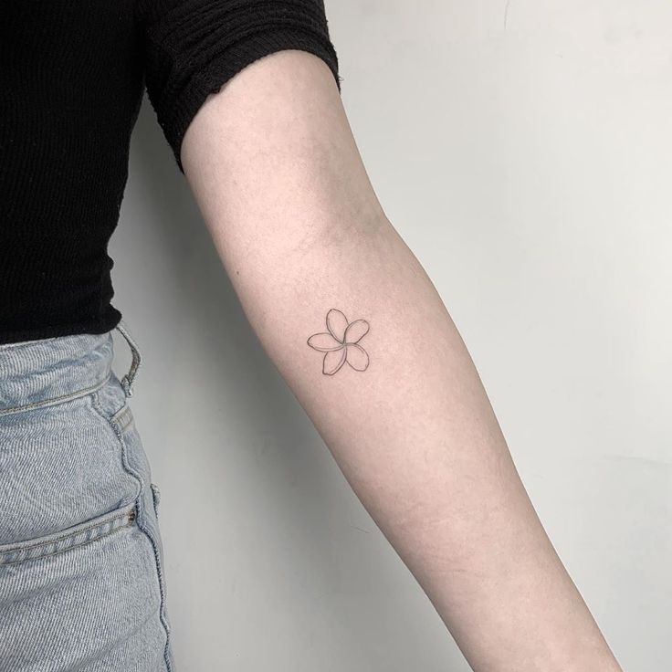 a person with a small flower tattoo on their arm