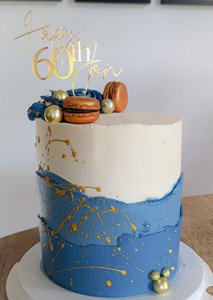 a blue and white cake with gold decorations