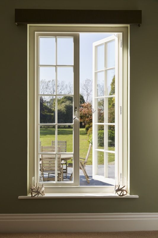 an open window with chairs and table in front of it