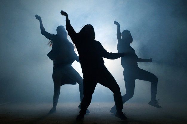 silhouettes of people dancing in the fog