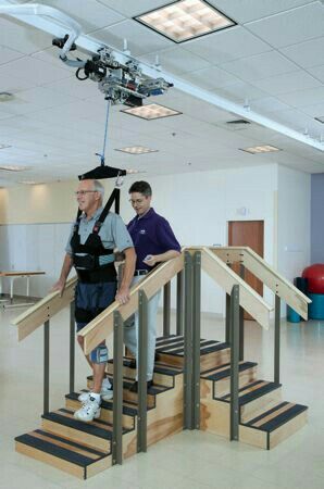 two men walking up some stairs in an office building with cameras on the ceiling above them