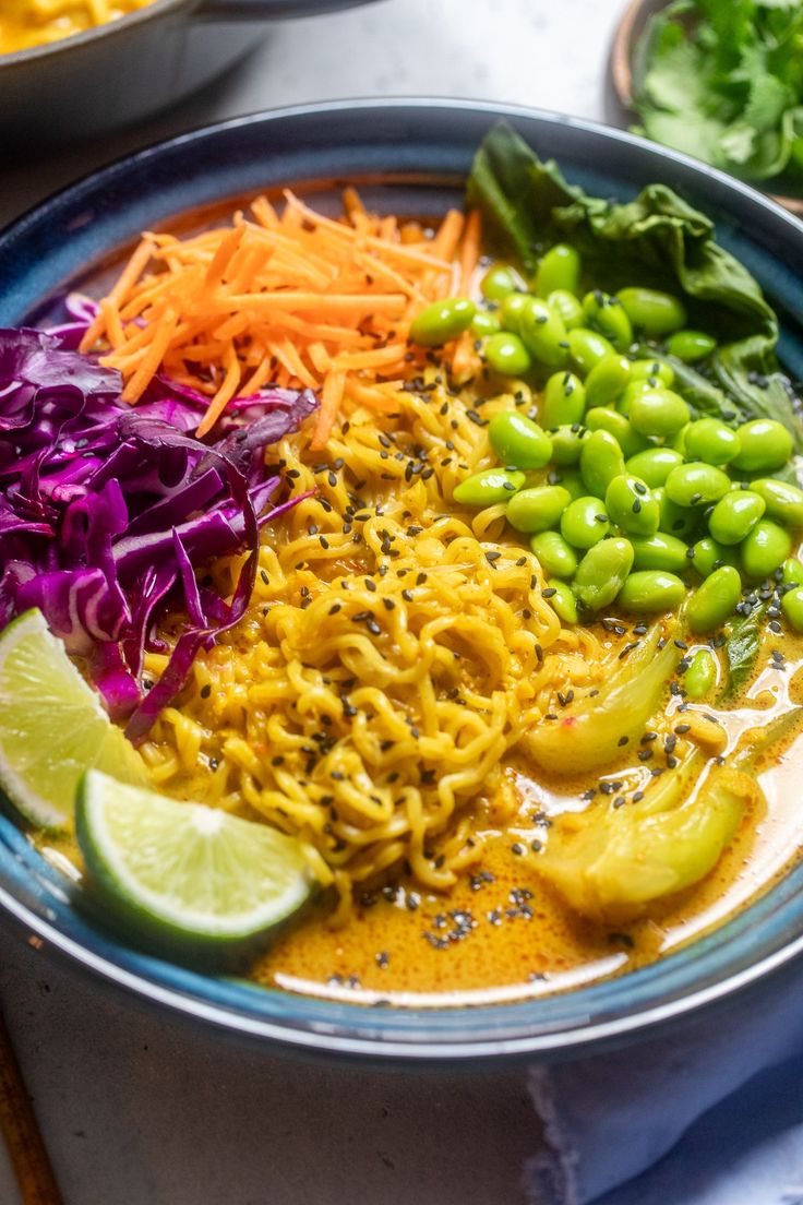 a bowl filled with noodles and vegetables on top of a table