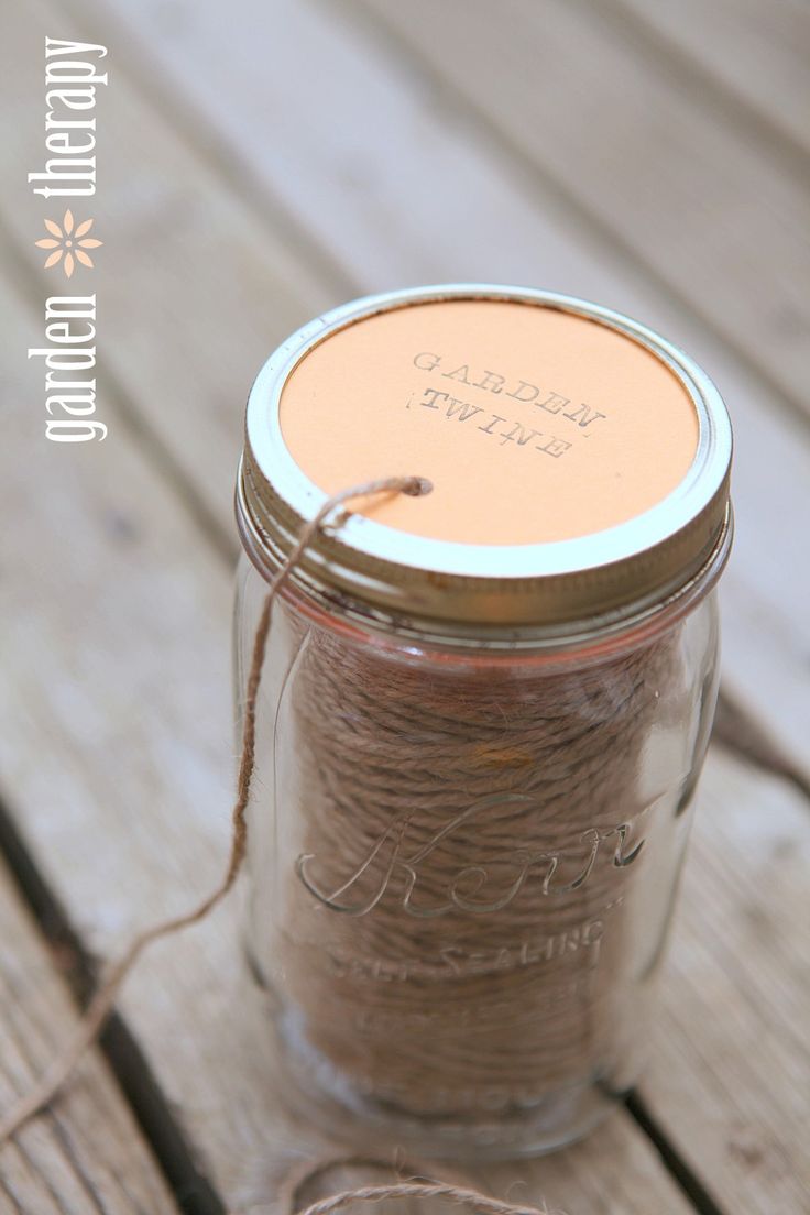 a glass jar filled with brown string on top of a wooden table