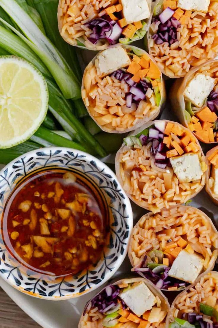 mexican rice rolls on a plate with dipping sauce