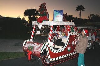 a person standing next to a decorated car with christmas decorations on the side and trees in the back