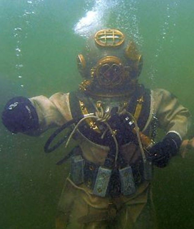 a scuba diver in the water with his gear on and hands out to the camera