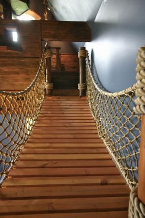 there is a rope bridge going over the water in this boat's dock area