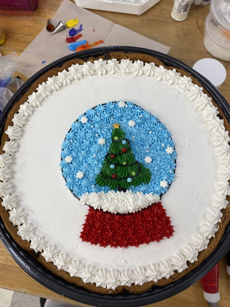 there is a cake decorated with a christmas tree on the top and red, white, and blue frosting