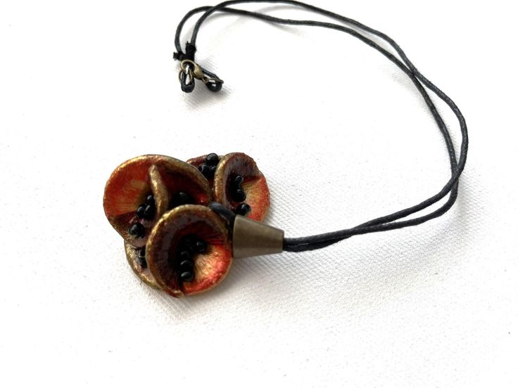 a necklace with two pieces of fruit hanging from it's side on a cord