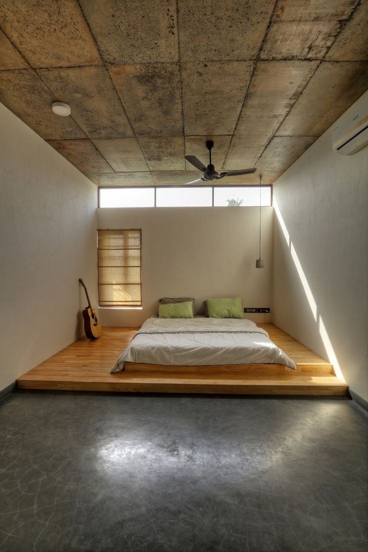 a bed sitting in the middle of a room under a ceiling fan