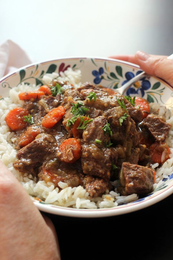 a bowl filled with rice, meat and carrots