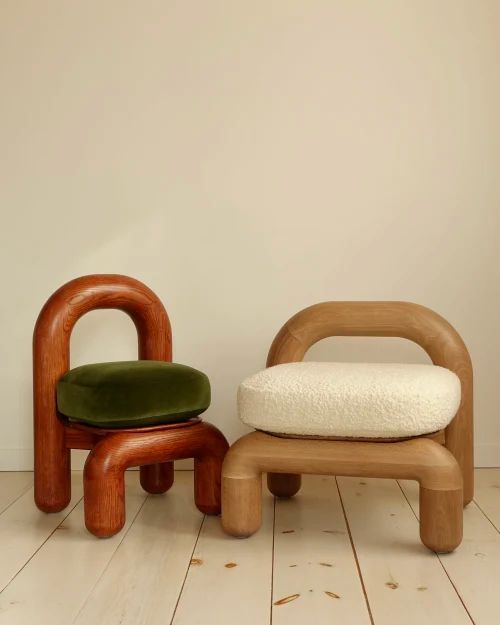 two wooden chairs sitting next to each other on top of a hard wood floored floor