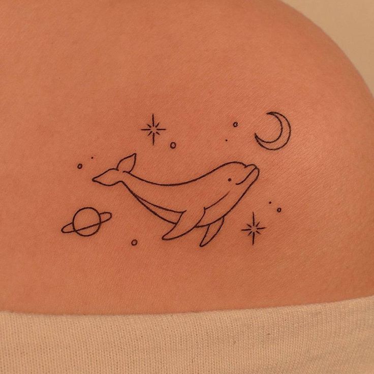 a woman with a tattoo on her stomach that has a dolphin and planets in it