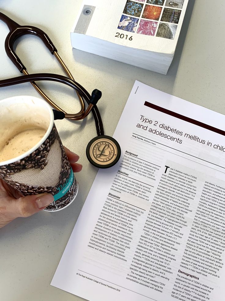 a person is holding a coffee cup next to a medical record