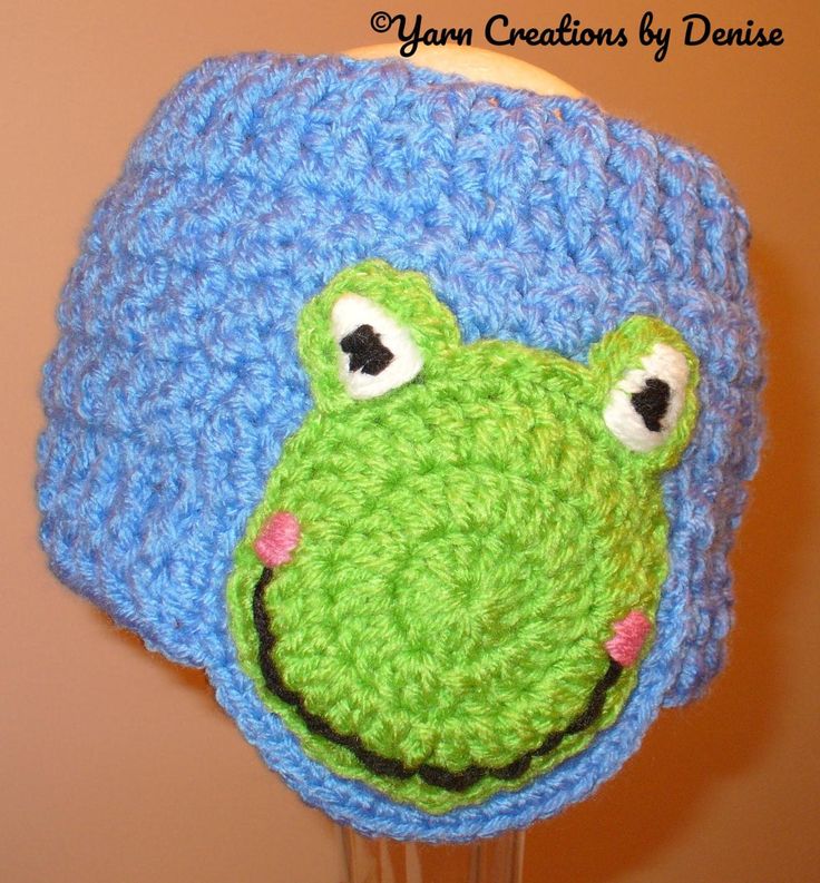 a crocheted hat with a green frog on it