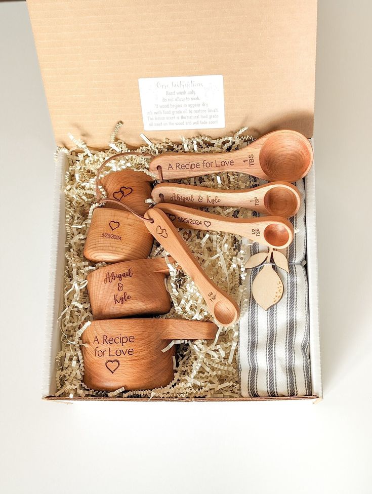 wooden spoons and measuring spoons are in a box with some writing on them