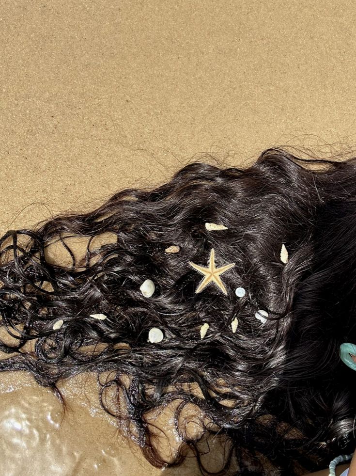 a woman laying on the floor with her long hair in curls and starfish decorations