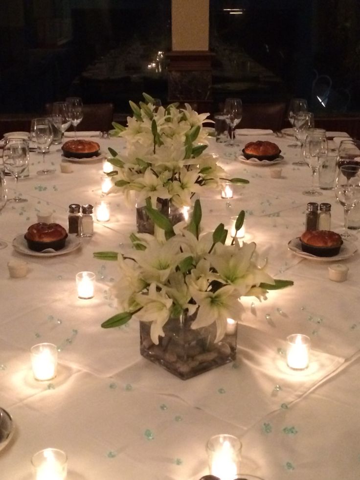 a table is set up with candles and flowers in vases on the centerpiece