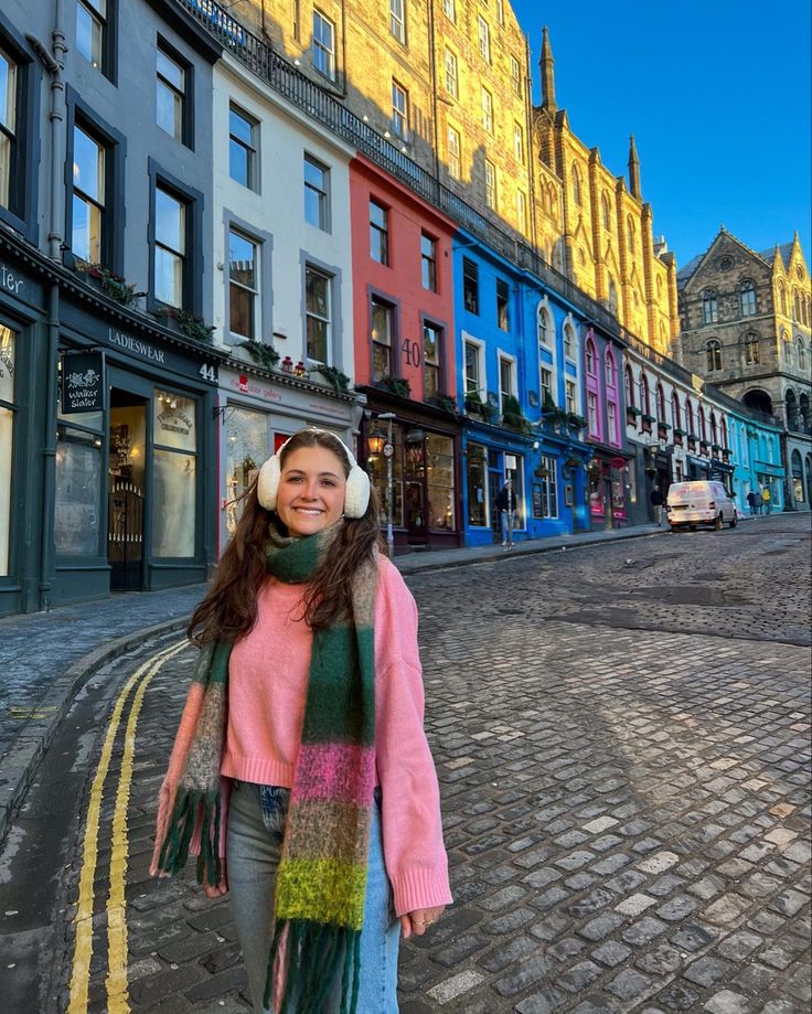 a woman is walking down the street with headphones on