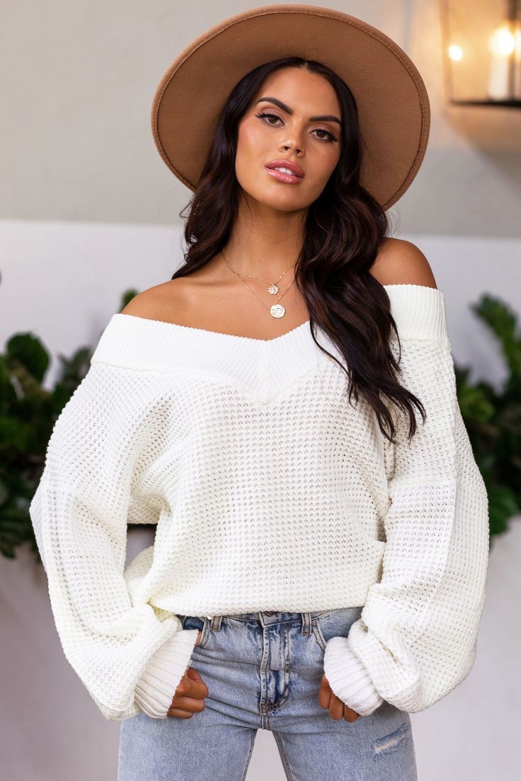 Standard  with class of "tabs"  Cue all the cozy cuddles in this cool-weather essential. Introducing our Ginny Ivory Knit Bell Sleeve Sweater made of a soft medium-weight knit fabric with an oversized fit and wide v-neckline to wear draped off the shoulder for an elegant yet effortless look. Featuring relaxed balloon sleeves with thick fitted cuffs, and a banded bottom and neckline. Top off the look with one of our Olivia Panama Hats. Knit Bell Sleeve, Cozy Cuddles, Bell Sleeve Sweater, Sweater Making, Balloon Sleeves, Bell Sleeve, Sleeve Sweater, Off Shoulder Blouse, Bell Sleeves