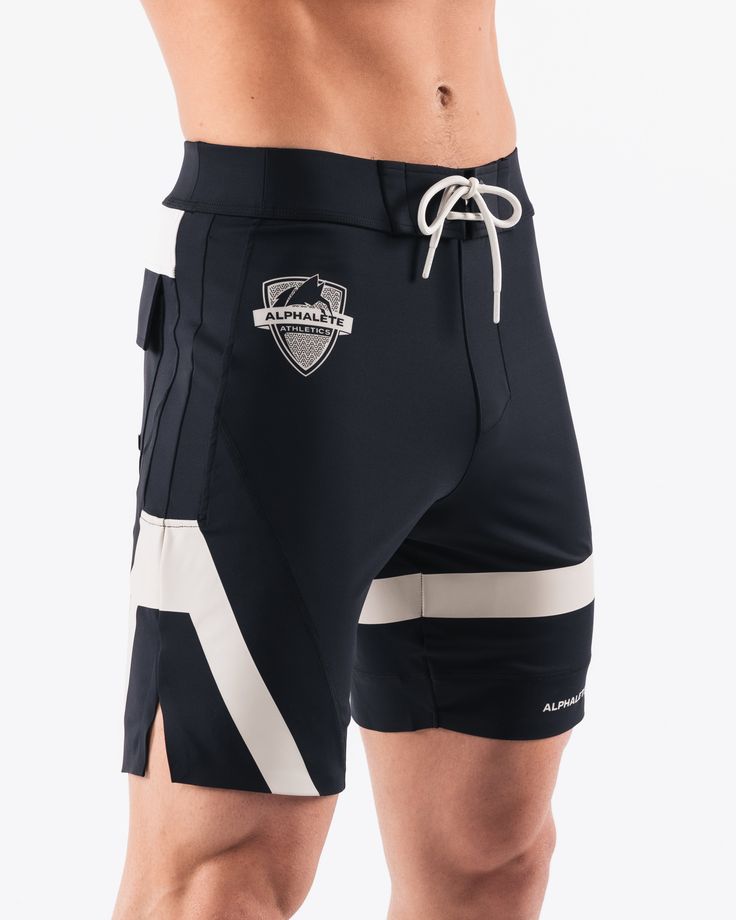 HIGHLIGHTS.. Unlined boardshort. 9” inseam Reflective branding at leg opening and back waistband Elastic waistband with adjustable self-tie drawcords Color-blocking panelling Water resistant fabric FIT SUGGESTION. This item runs true to Alphalete’s standard sizing.. Fit is based off of waist size in inches.. If you are between sizes, we recommend sizing up for a relaxed fit.. Eric is 6’2”/188cm, wearing a size 32. MATERIALS AND WASHING DIRECTIONS. 67% Nylon, 23% spandex. Due to the high saturati Functional Black Short Swimwear, Sporty Fitted Shorts With Functional Drawstring, White Drawstring Bottoms For Outdoor, Functional Black Athletic Shorts For Beach, Sporty Nylon Athletic Shorts For Surfing, Sporty Surfing Bottoms With Elastic Waistband, Black Athleisure Swim Trunks With Functional Drawstring, Black Athleisure Activewear For Surfing, Athleisure Athletic Shorts For Surfing