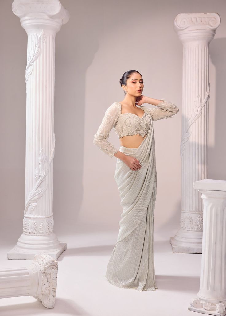 An exquisit Italian imported fabric being the key highlight of this ensemble which is sure to never go out of trend. An artistic symphony of fine aari embroidery adorns the blouse with full sleeves. It has 3D katdana loops, this unreal detailing enhance the ethreal look of the outfit. Colour: Glacier Gray Material: Italian - Saree, Organza- Blouse No of components: 2 Surface Ornamentation: Hand Embroidery Care Instructions: Dry Clean Shipping Time: 3-4 weeks Elegant Embroidered Pre-draped Georgette Saree, Elegant Designer Pre-draped Saree With Resham Embroidery, Designer Sets With Resham Embroidery And Long Sleeve, Embellished Long Sleeve Pre-draped Saree For Party, Designer Long Sleeve Sets With Resham Embroidery, Long Sleeve Resham Embroidery Pre-draped Saree For Festive, Embroidered Long Sleeve Pre-draped Saree For Reception, Long Sleeve Choli In Georgette, Designer Long Sleeve Lehenga With Cutdana