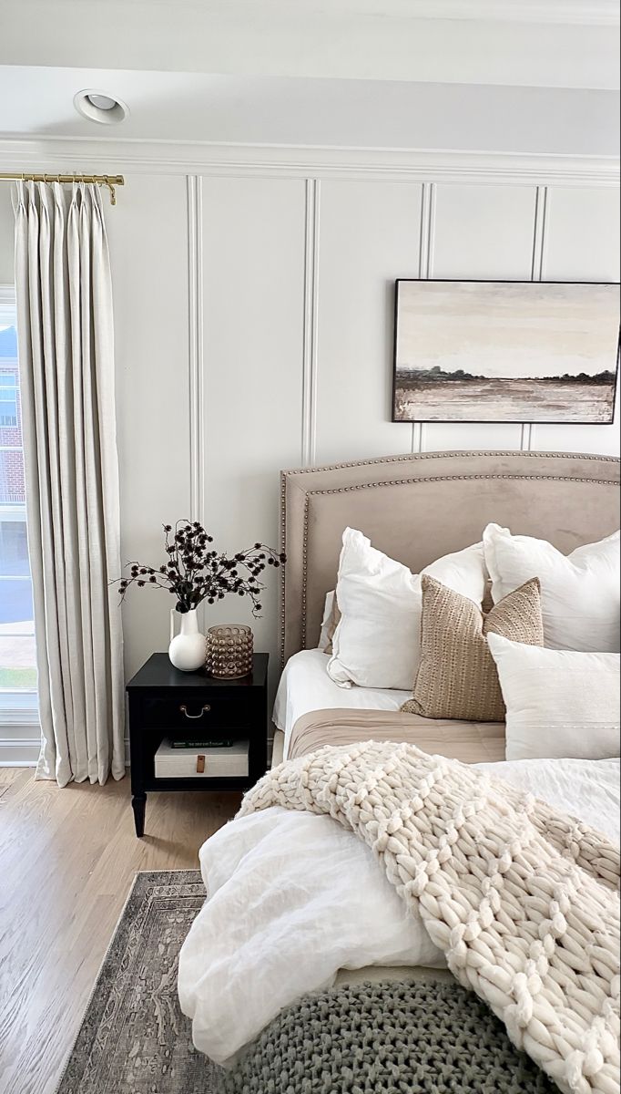 a bedroom with white walls and wood floors