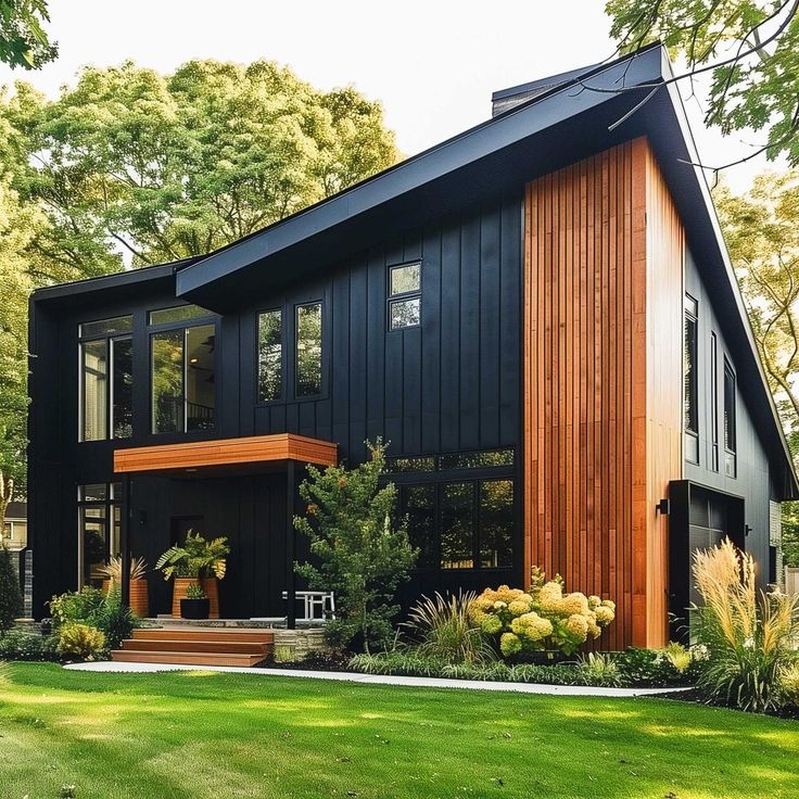 a large black house with wood trimmings on the front and side of it