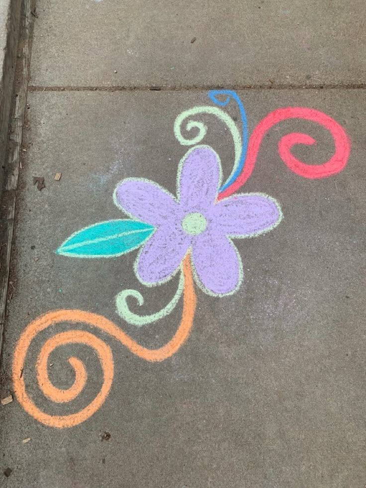 the sidewalk is painted with colorful chalk and has a flower on it