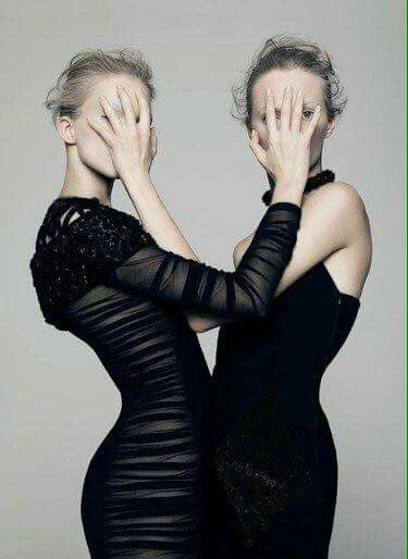 two women in black dresses covering their faces