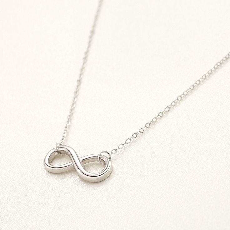 These beautiful necklaces will make the day of the most demanding sights! Carefully crafted with high-quality 925 Rhodium Plated Silver, bearing a beautiful design, these exclusive necklaces from our new collection will become a great present for your loved ones. The sterling silver infinity symbol pendant represents endless love and connection, making it a thoughtful gift or a meaningful addition to your own jewelry collection. Product Details: Metal: Sterling Silver Base Metal Purity: 925 Plat Sterling Silver Infinity Necklace In White Gold, Classic White Gold Infinity Necklace, Classic Sterling Silver Infinity Necklace, Minimalist White Gold Infinity Necklace, Infinity Clavicle Chain Necklace As Gift, Classic Silver Infinity Jewelry, Minimalist Infinity Necklace In White Gold, Dainty Silver Infinity Necklace, Minimalist Sterling Silver Infinity Necklace