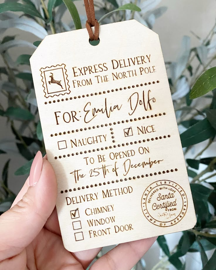 a hand holding a wooden luggage tag with the words express delivery from the north pole