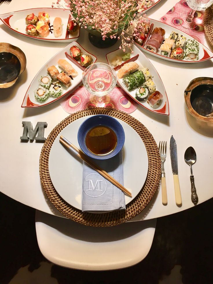 a white table topped with plates and bowls filled with food