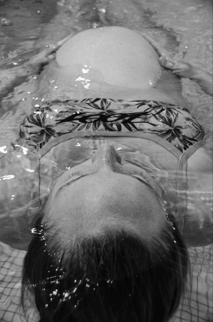 a woman swimming in a pool with her head above the water