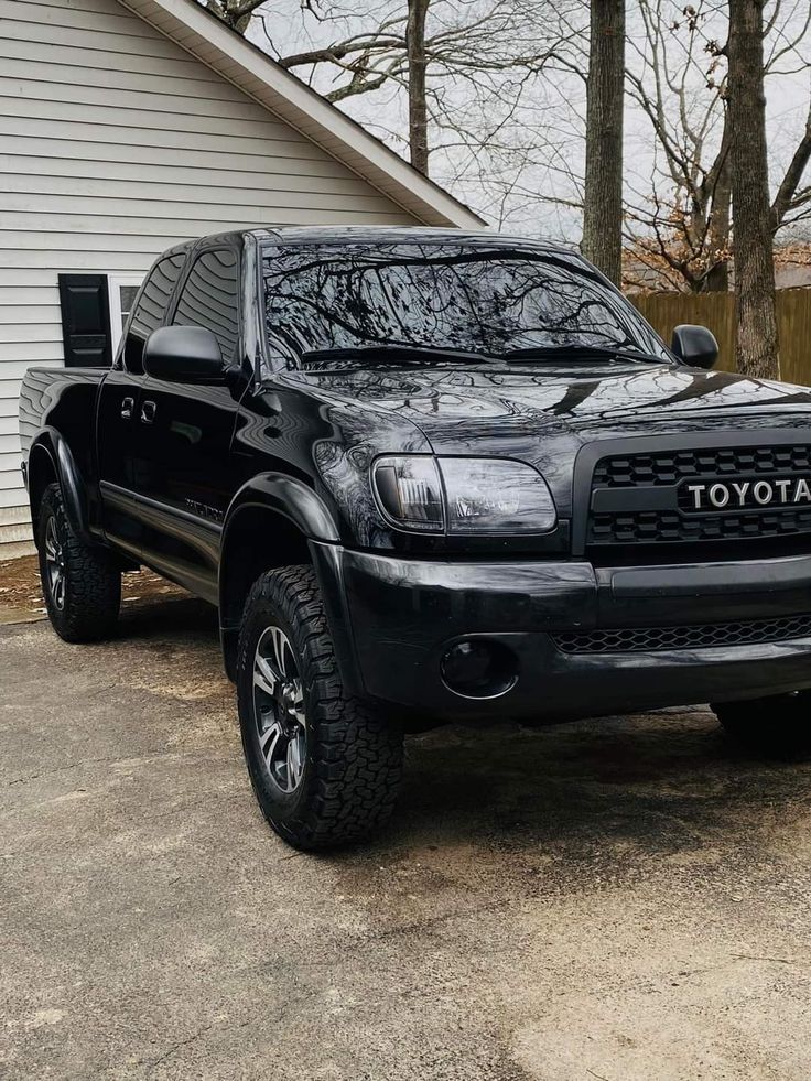 a black toyota truck parked in front of a house