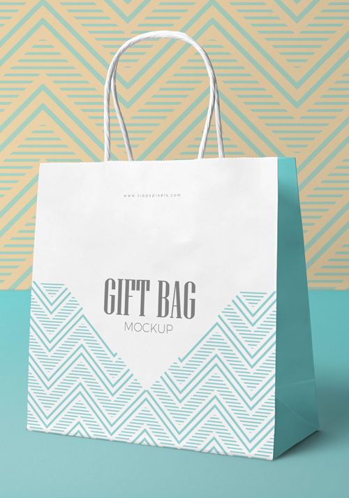 a white shopping bag with the words gift bag mockup on it against a geometric background