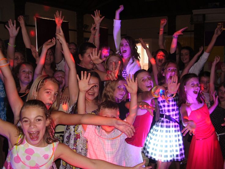 a large group of young people standing next to each other with their hands in the air