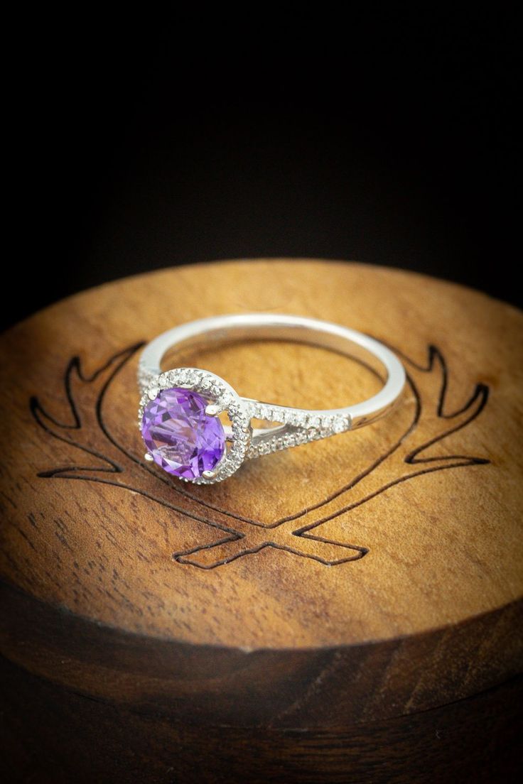 a close up of a ring on top of a wooden box with an engraved design