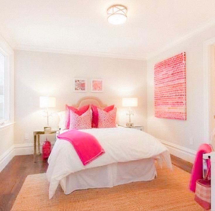 a bedroom with white walls and pink accents