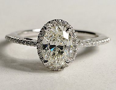 an oval cut diamond ring with pave diamonds on the band