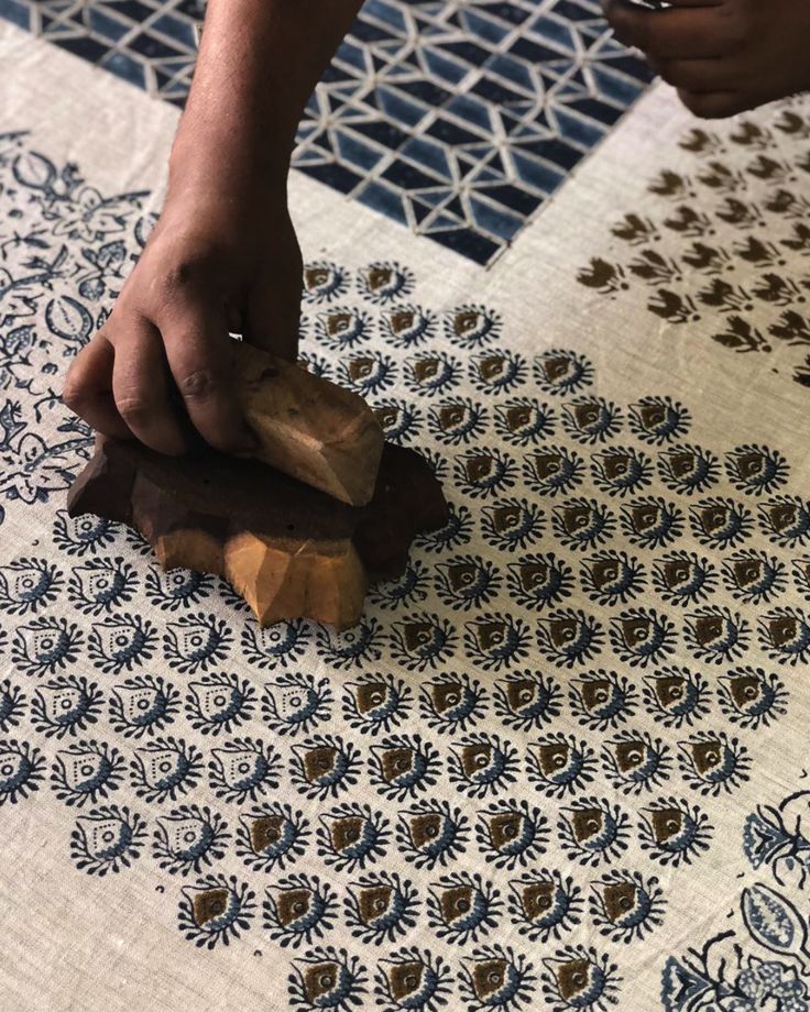 a person using a wood block to cut up a piece of wood on the floor