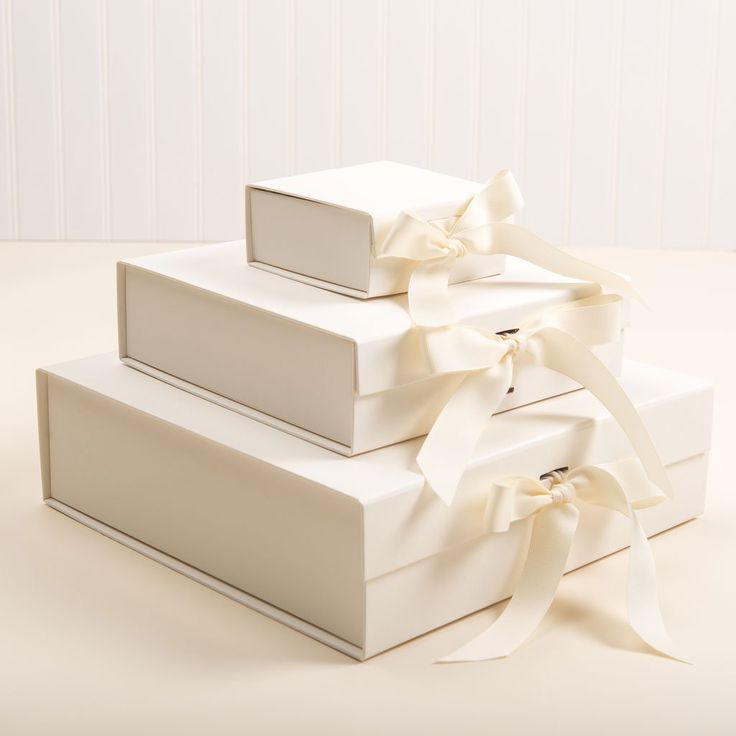 three white boxes with ribbons tied around them