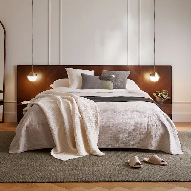 a bed with two lamps on either side of the headboard and foot board in front of it