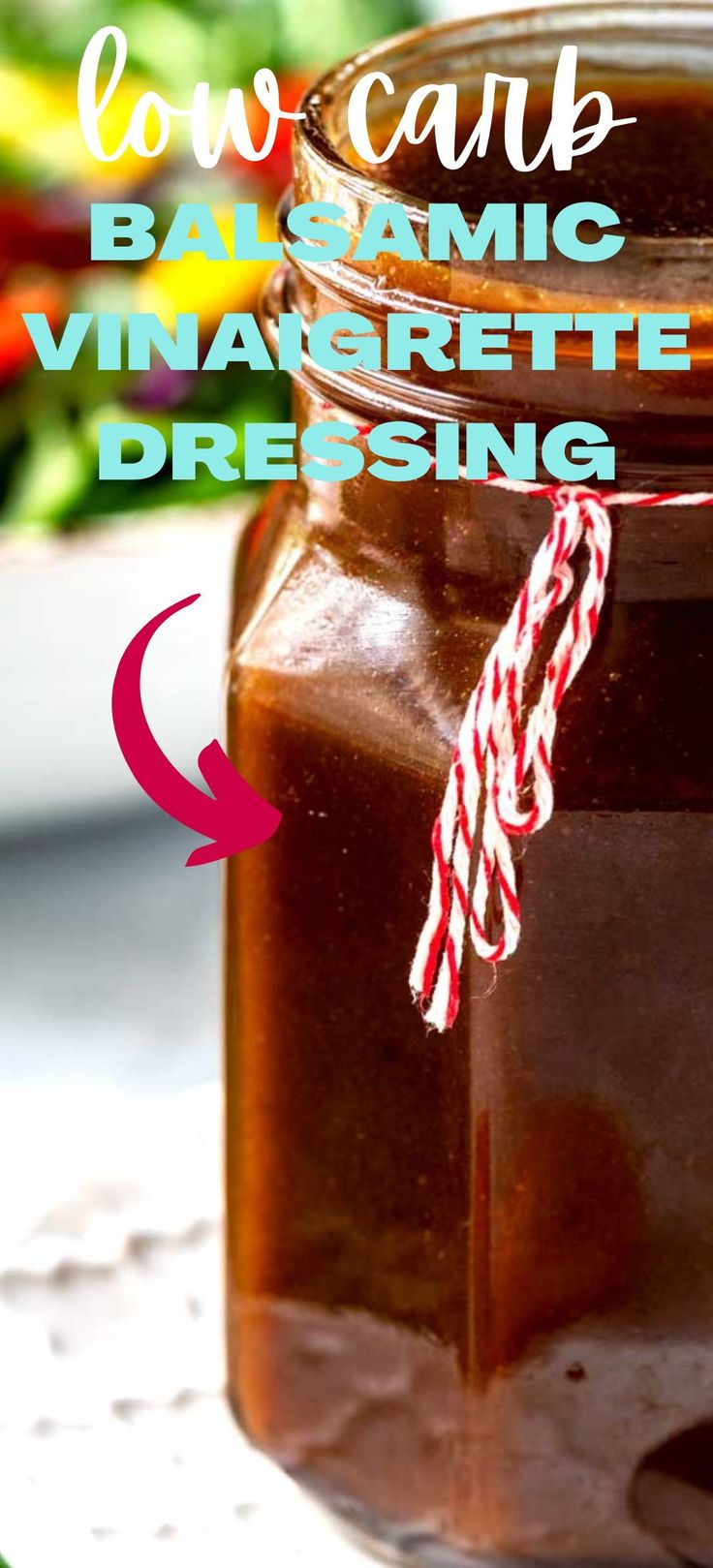 a jar filled with brown liquid sitting on top of a table next to a salad