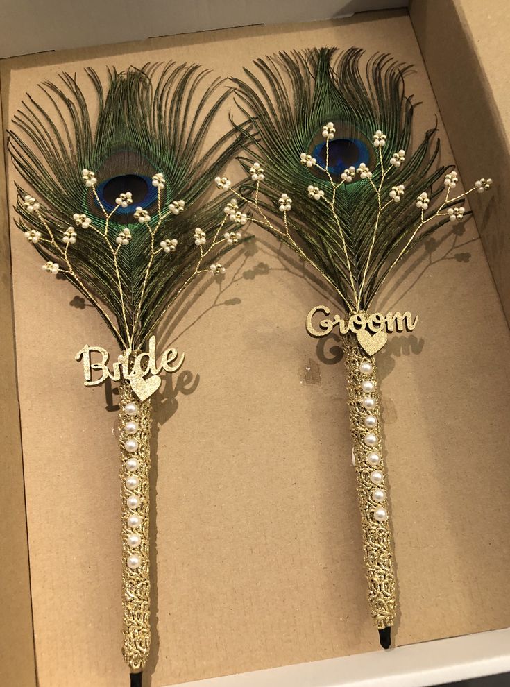 two peacock feathers on top of each other with the word bride and groom written on them