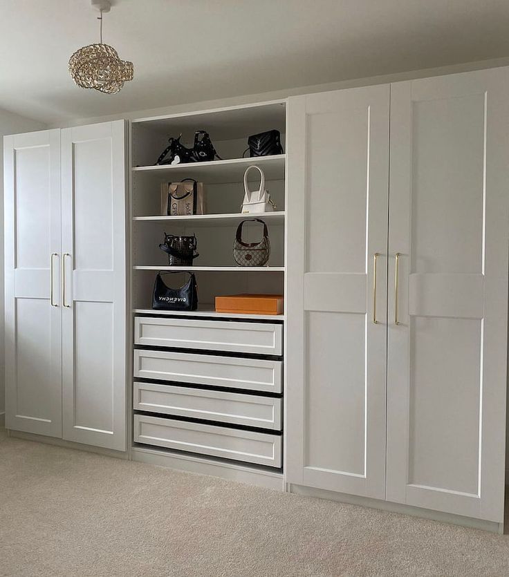 a white closet with many drawers and shoes on it's shelves in a room