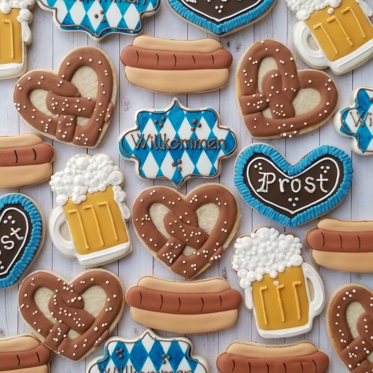 decorated cookies with beer, hot dogs and pretzels are arranged on a table