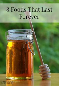 a jar filled with honey sitting on top of a table next to a wooden spoon