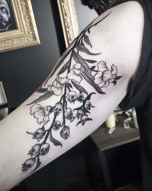 a woman's arm with flowers and leaves tattooed on the left side of her body