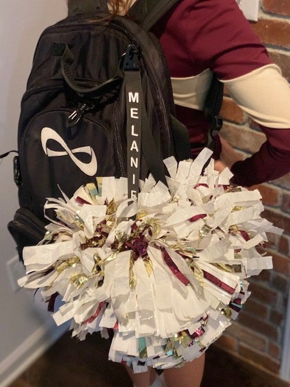 a woman wearing a backpack and holding a bunch of pieces of paper in her hands